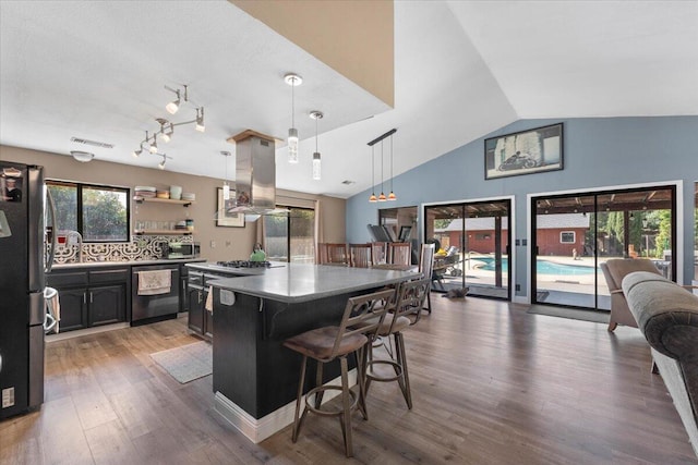 2025 El Verano St, Redding, CA 96002 - kitchen featuring stainless steel appliances, island range hood, a breakfast bar, wood finished floors, and a kitchen island