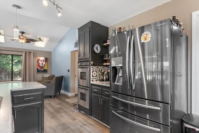 2025 El Verano St, Redding, CA 96002 - kitchen with appliances with stainless steel finishes, vaulted ceiling, a skylight, a ceiling fan, and light countertops