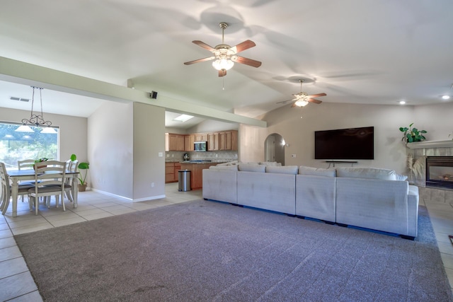 17400 Pittim Dr, Redding, CA 96003 - living area featuring lofted ceiling, a ceiling fan, light tile patterned floors, a tile fireplace, and baseboards
