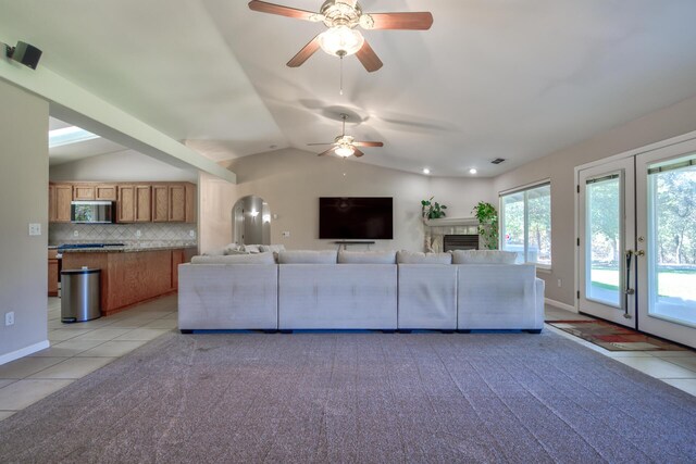 17400 Pittim Dr, Redding, CA 96003 - living area with light tile patterned flooring, lofted ceiling, ceiling fan, a fireplace, and light carpet