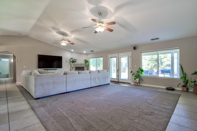 17400 Pittim Dr, Redding, CA 96003 - living area featuring light tile patterned floors, a ceiling fan, arched walkways, lofted ceiling, and a fireplace