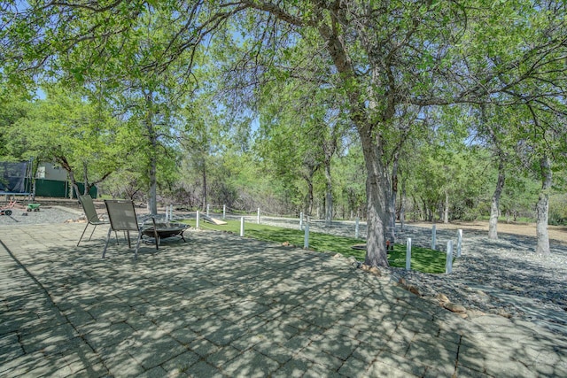 17400 Pittim Dr, Redding, CA 96003 - wooden terrace with an outdoor fire pit, a trampoline, and a patio area