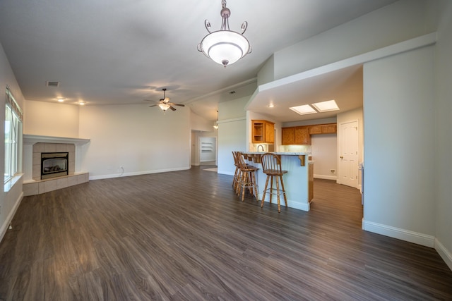3255 Wandsworth Dr, Shasta Lake, CA 96019 - unfurnished living room featuring a tiled fireplace, dark wood-type flooring, and ceiling fan
