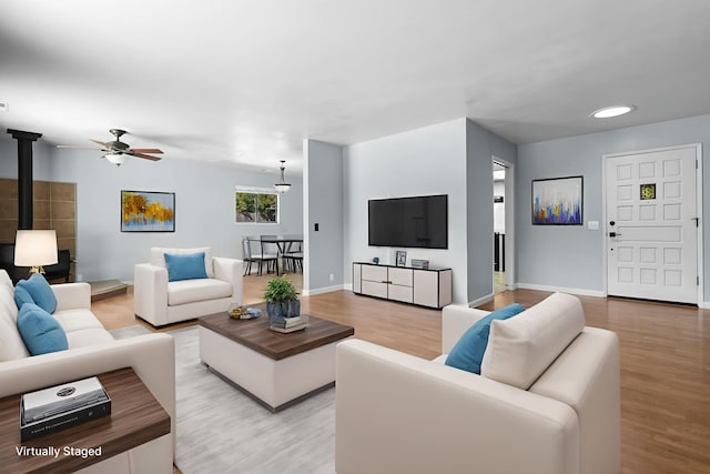 1401 Casa Vereda Way, Redding, CA 96003 - living area featuring a wood stove, ceiling fan, and wood finished floors