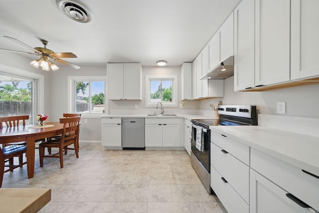 2034 Wilder Dr, Redding, CA 96002 - kitchen featuring stainless steel appliances, a sink, under cabinet range hood, and plenty of natural light