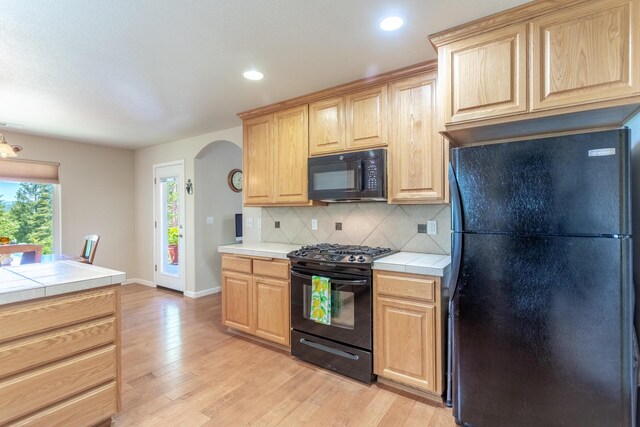 7256 Shasta Forest Dr, Shingletown, CA 96088 - kitchen featuring black appliances, tile countertops, arched walkways, light brown cabinetry, and recessed lighting