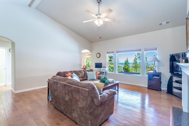 7256 Shasta Forest Dr, Shingletown, CA 96088 - living area featuring arched walkways, ceiling fan, wood finished floors, baseboards, and high vaulted ceiling