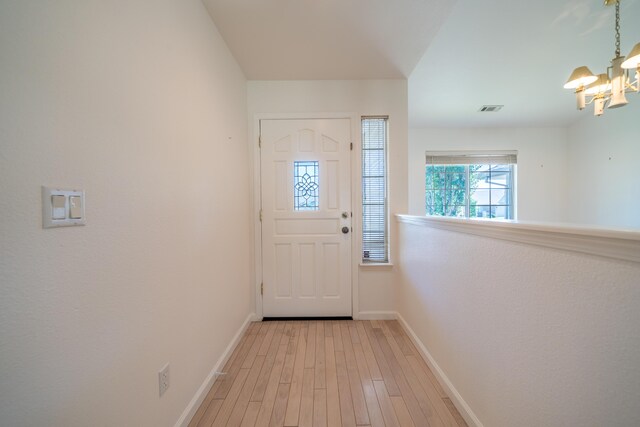 2169 Hope Ln, Redding, CA 96003 - doorway to outside featuring a chandelier, baseboards, and light wood-style floors