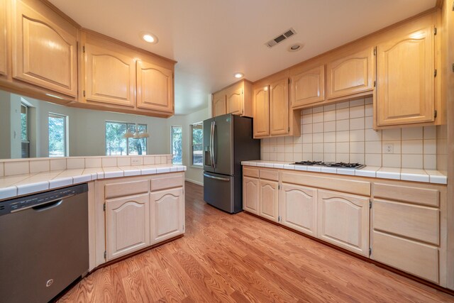2169 Hope Ln, Redding, CA 96003 - kitchen with stainless steel fridge, dishwasher, light brown cabinets, light wood-style floors, and recessed lighting