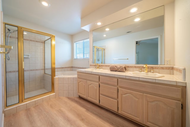 2169 Hope Ln, Redding, CA 96003 - bathroom featuring double vanity, a bath, a stall shower, wood finished floors, and recessed lighting