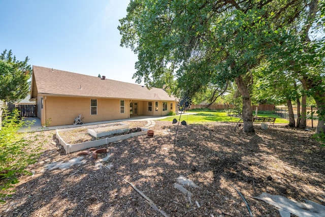 2169 Hope Ln, Redding, CA 96003 - back of property with a fenced backyard, a patio, a shingled roof, and stucco siding