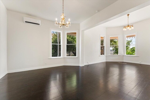 1764 Chestnut St, Redding, CA 96001 - unfurnished room with a chandelier, a wall unit AC, and dark wood-style floors