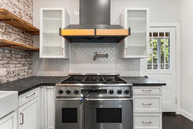 1764 Chestnut St, Redding, CA 96001 - kitchen with range with two ovens, wall chimney range hood, glass insert cabinets, and decorative backsplash