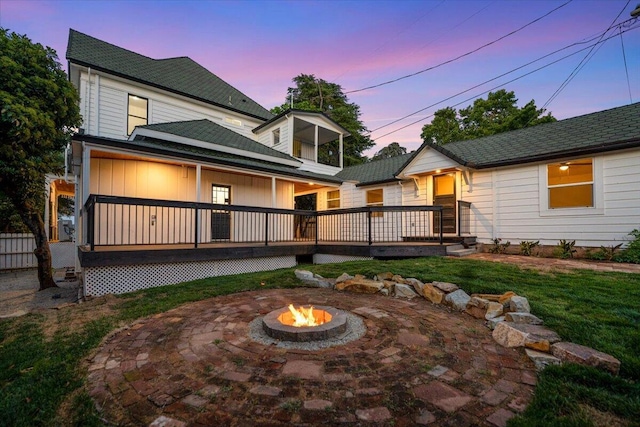 1764 Chestnut St, Redding, CA 96001 - back of house at dusk featuring a fire pit, a yard, a patio area, and a deck