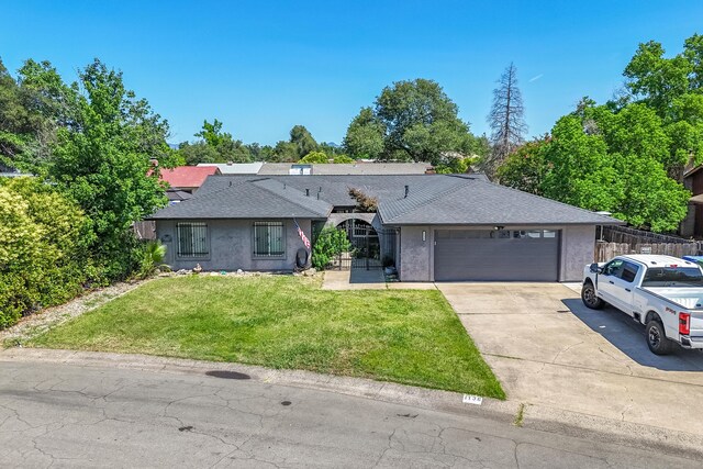 1136 Woodland Ter, Redding, CA 96002 - single story home with driveway, an attached garage, a front yard, roof with shingles, and stucco siding
