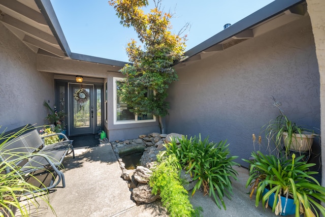 1136 Woodland Ter, Redding, CA 96002 - view of exterior entry featuring stucco siding and a patio area