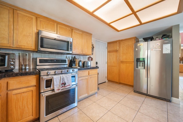 1136 Woodland Ter, Redding, CA 96002 - kitchen with appliances with stainless steel finishes, tasteful backsplash, light tile patterned floors, and tile counters