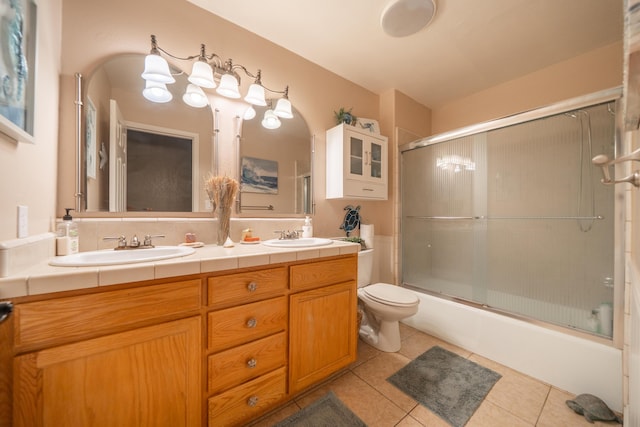 1136 Woodland Ter, Redding, CA 96002 - full bath with tile patterned flooring, double vanity, toilet, and bath / shower combo with glass door