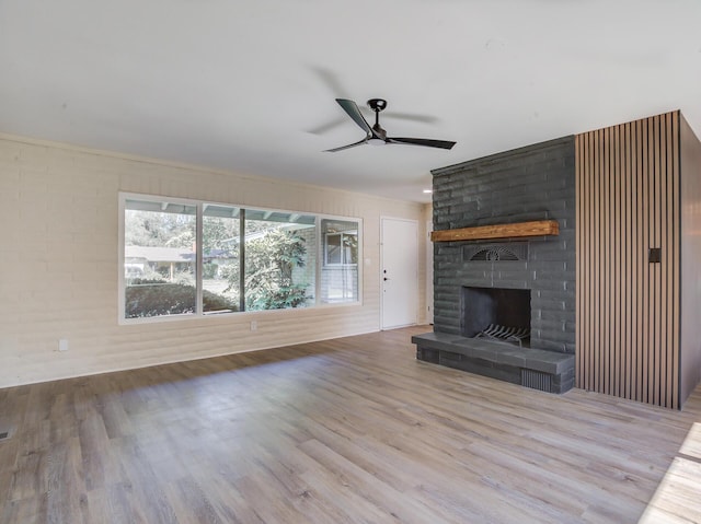 3090 Inez St, Redding, CA 96002 - unfurnished living room with wood finished floors, ceiling fan, and a brick fireplace