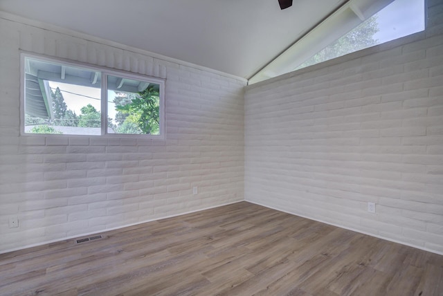 3090 Inez St, Redding, CA 96002 - spare room featuring lofted ceiling, brick wall, and wood finished floors