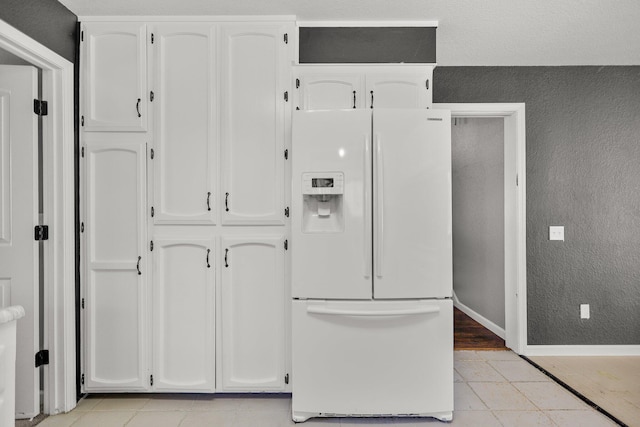 2420 Ostling Ave, Shasta Lake, CA 96019 - kitchen with white refrigerator with ice dispenser, white cabinets, light tile patterned flooring, and a textured wall