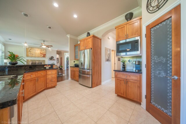 3179 Pinot Path, Redding, CA 96001 - kitchen featuring stainless steel appliances, ornamental molding, tasteful backsplash, ceiling fan, and a fireplace