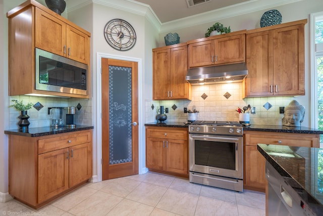 3179 Pinot Path, Redding, CA 96001 - kitchen with under cabinet range hood, stainless steel gas range, built in microwave, ornamental molding, and tasteful backsplash