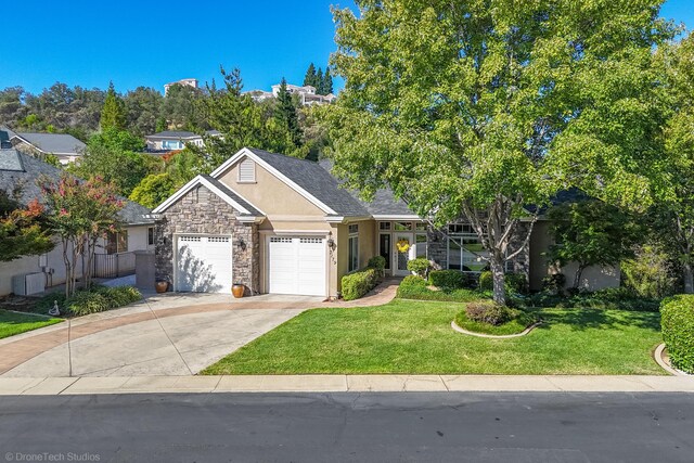 3179 Pinot Path, Redding, CA 96001 - ranch-style home with stucco siding, stone siding, an attached garage, a front yard, and concrete driveway
