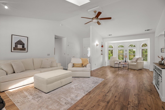 21247 Creekside Dr, Red Bluff, CA 96080 - living area with vaulted ceiling, wood finished floors, a ceiling fan, and a skylight