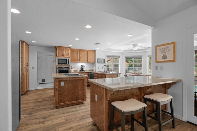 21247 Creekside Dr, Red Bluff, CA 96080 - kitchen with stainless steel appliances, a peninsula, recessed lighting, a kitchen island, and light wood-style floors