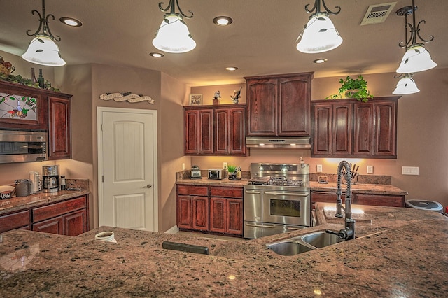 13787 Walter Ave, Redding, CA 96003 - kitchen with appliances with stainless steel finishes, under cabinet range hood, a sink, light stone countertops, and hanging light fixtures