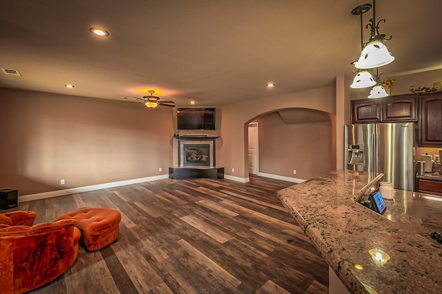 13787 Walter Ave, Redding, CA 96003 - unfurnished living room with arched walkways, a ceiling fan, dark wood finished floors, baseboards, and a glass covered fireplace