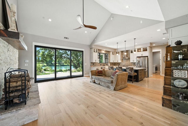 180 Agua Verdi Dr, Red Bluff, CA 96080 - living area with high vaulted ceiling, light wood finished floors, a ceiling fan, a stone fireplace, and recessed lighting