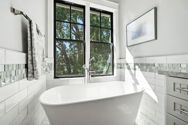 180 Agua Verdi Dr, Red Bluff, CA 96080 - bathroom featuring tile walls, a freestanding bath, and wainscoting