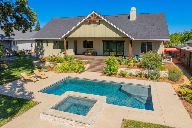 180 Agua Verdi Dr, Red Bluff, CA 96080 - back of property with an in-ground hot tub, a chimney, a patio area, board and batten siding, and roof with shingles