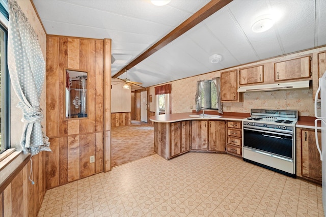 7530 Brett Rd, Shingletown, CA 96088 - kitchen featuring white gas range, a peninsula, under cabinet range hood, wood walls, and light flooring