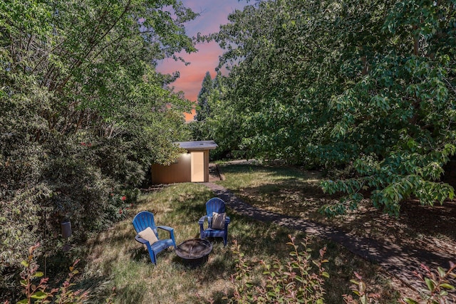 1545 Olive Ave, Redding, CA 96001 - yard at dusk featuring a storage unit and an outdoor fire pit