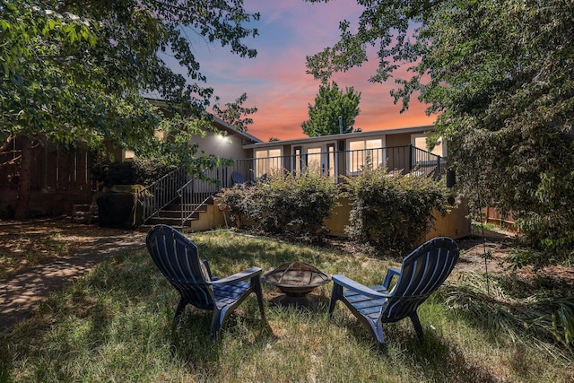 1545 Olive Ave, Redding, CA 96001 - back of house at dusk featuring a fire pit, stairway, and a wooden deck