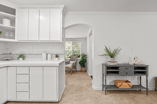 1545 Olive Ave, Redding, CA 96001 - kitchen featuring arched walkways, light countertops, white cabinetry, tasteful backsplash, and crown molding