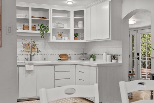 1545 Olive Ave, Redding, CA 96001 - kitchen featuring arched walkways, light countertops, white cabinetry, and tasteful backsplash