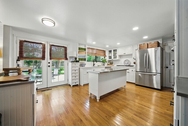 6966 Granada Dr, Redding, CA 96002 - kitchen with freestanding refrigerator, plenty of natural light, white cabinetry, and recessed lighting