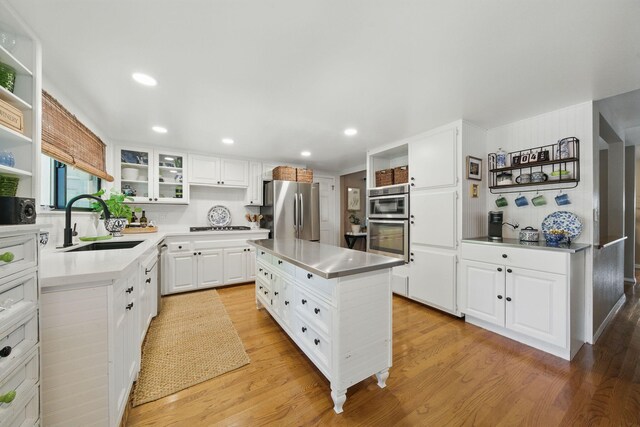 6966 Granada Dr, Redding, CA 96002 - kitchen with appliances with stainless steel finishes, open shelves, a sink, light wood-style flooring, and recessed lighting