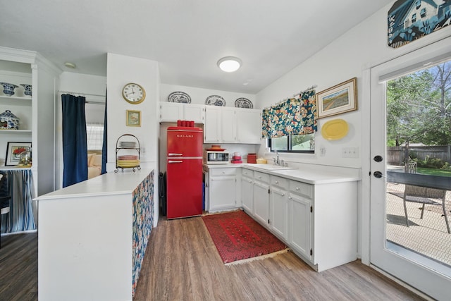 6966 Granada Dr, Redding, CA 96002 - kitchen with wood finished floors, white microwave, a sink, white cabinetry, and light countertops