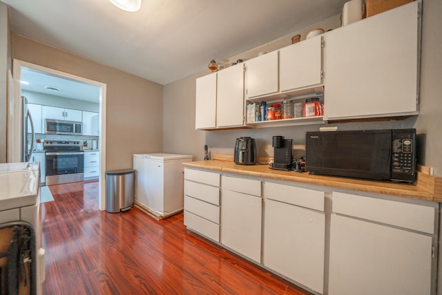 37255 Carson St, Burney, CA 96013 - kitchen featuring appliances with stainless steel finishes, dark wood finished floors, white cabinetry, light countertops, and open shelves