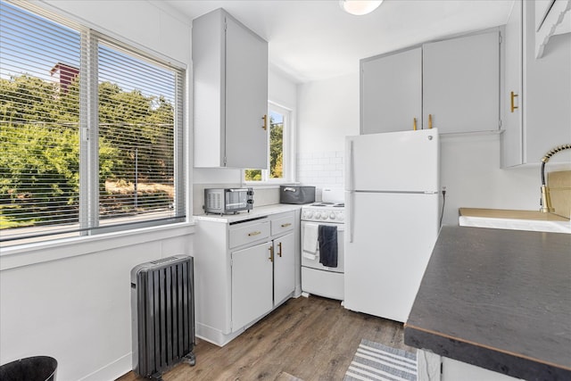 2005 E St, Redding, CA 96001 - kitchen with radiator, white appliances, wood finished floors, and backsplash
