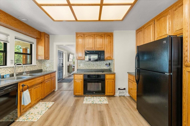 4400 Allen St, Dunsmuir, CA 96025 - kitchen featuring black appliances, a sink, light wood finished floors, decorative backsplash, and brown cabinets