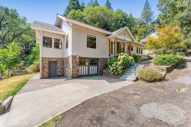 4400 Allen St, Dunsmuir, CA 96025 - view of front of home featuring stone siding, concrete driveway, a garage, a porch, and stairs