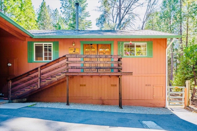 30821 Bambi Dr, Shingletown, CA 96088 - back of house with a shingled roof, covered porch, and stairs