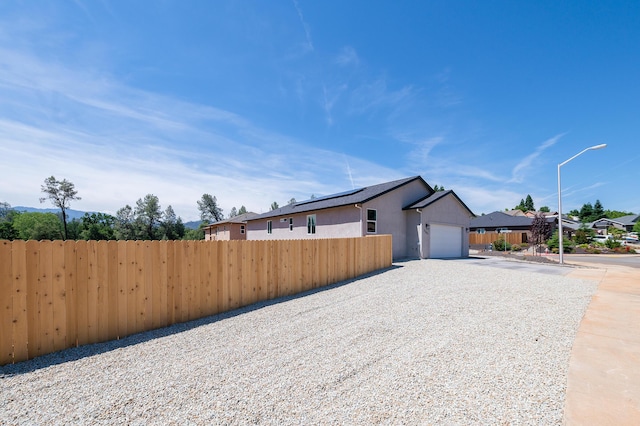 3707 Bloomsbury Ave, Shasta Lake, CA 96019 - view of property exterior with driveway, an attached garage, and stucco siding