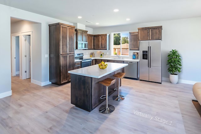 3707 Bloomsbury Ave, Shasta Lake, CA 96019 - kitchen with appliances with stainless steel finishes, a kitchen breakfast bar, light countertops, light wood-type flooring, and recessed lighting